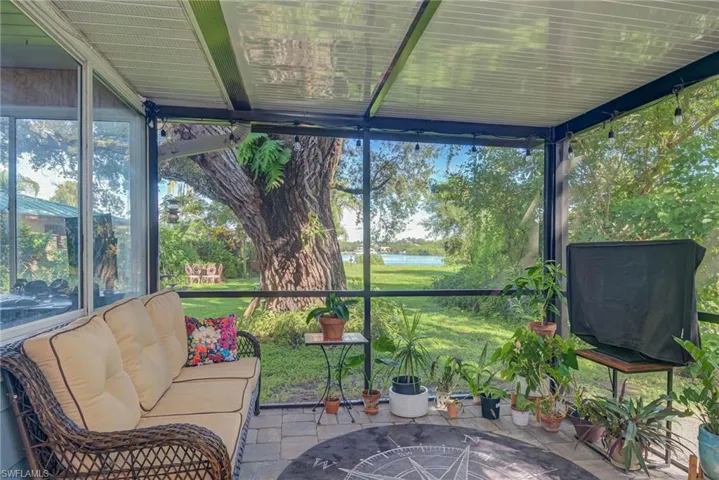 Sunroom / solarium with a water view and stone tile flooring