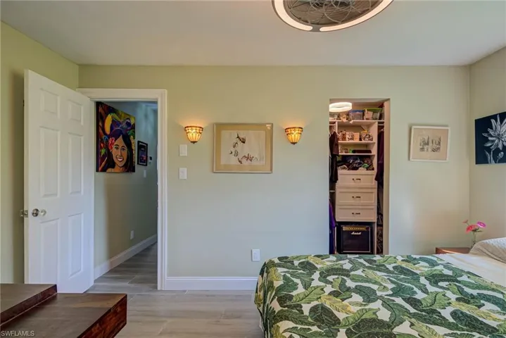 Bedroom with a walk in closet and light wood-style flooring