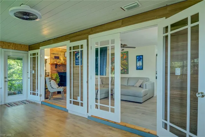 Doorway featuring wood finished floors, wooden walls, and a sunroom