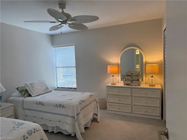 Bedroom with ceiling fan and light tile patterned floors