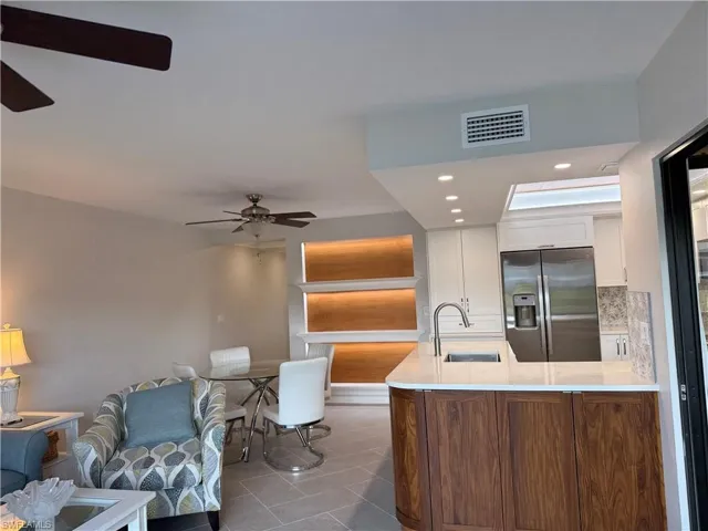 Kitchen featuring stainless steel fridge with ice dispenser, ceiling fan, white cabinets, recessed lighting, and tasteful backsplash