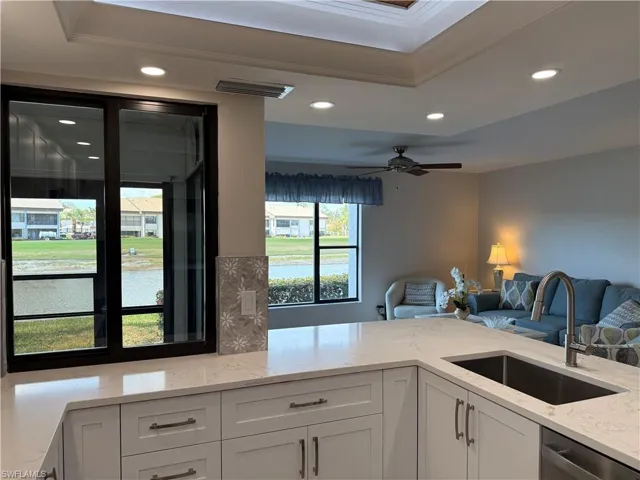 Kitchen with light stone countertops, open floor plan, recessed lighting, white cabinetry, and ceiling fan