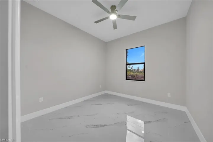 Empty room with marble finish floors and ceiling fan