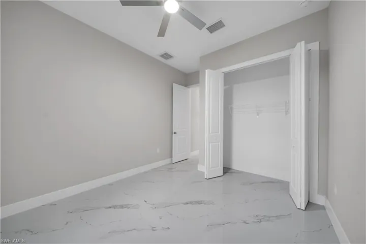 Unfurnished bedroom featuring ceiling fan and a closet