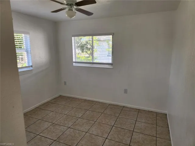Spare room with ceiling fan and light tile floors