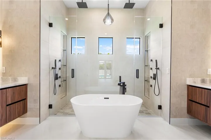 LUXURIOUS MASTER BATHROOM w/ FULL GLASS WALL, DOUBLE RAINFALL SHOWERS w/ FOUR JETS on each side, and HANDHELD SHOWERHEADS.