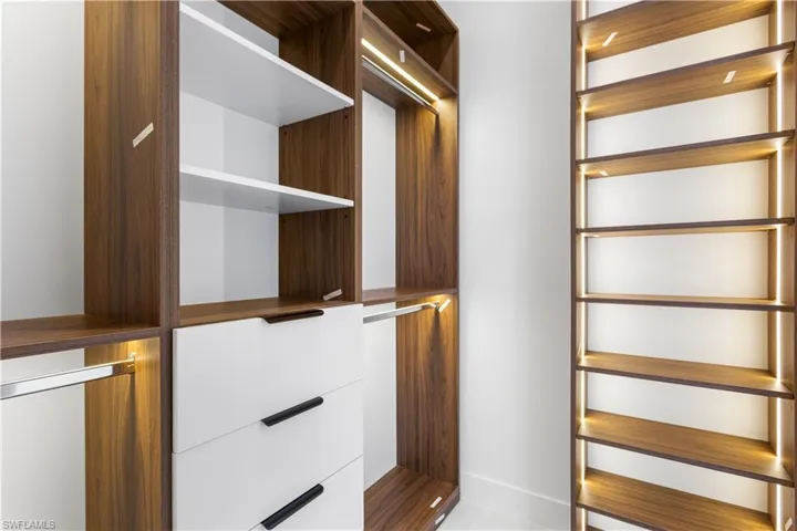 HIS & HER WALK-IN CLOSETS w/ LED lights into CUSTOM CABINETS, providing ample STORAGE SPACE.