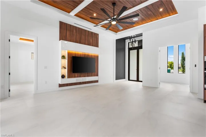 FEATURE WALL w/ WOOD PANELING & SHELVING w/ LED lights, 75-inch TV & WIRED BOSE SURROUND SOUND SYSTEM for PERFECT AMBIANCE.