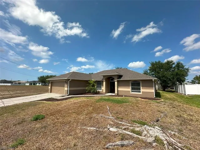 Single story home featuring driveway, stucco siding, and a garage