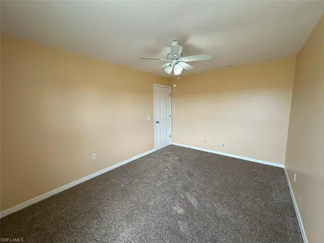 3rd Bedroom with dark carpet, a ceiling fan, and baseboards