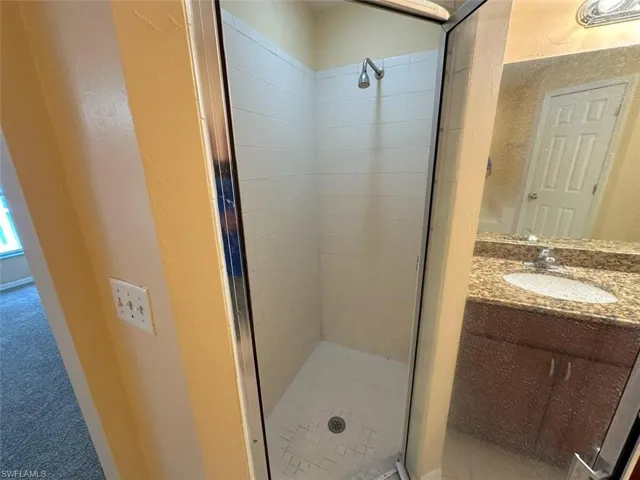 Full bath featuring a stall shower and vanity