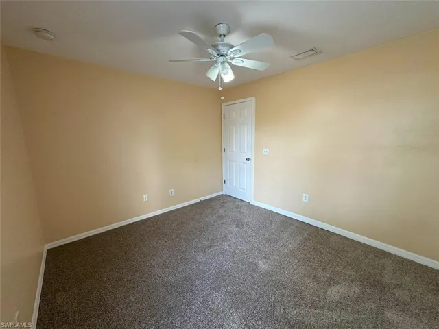 4th Bedroom featuring a ceiling fan, dark colored carpet, and baseboards