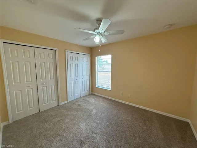 4th Bedroom featuring two closets, carpet floors, and baseboards