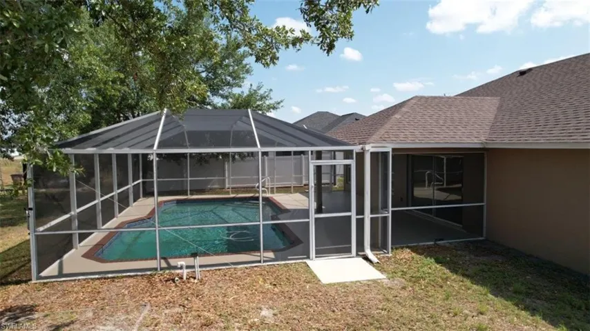Swimming pool featuring a patio, a lanai, and a yard