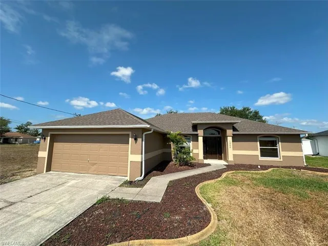 Single story home with stucco siding, an attached garage, concrete driveway, a front yard, and roof with shingles