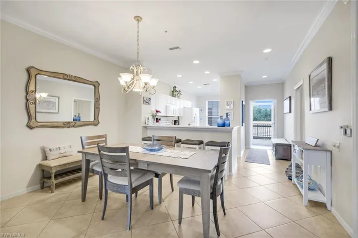 Dining area featuring crown molding, suspended lighting, and light tile patterned floors