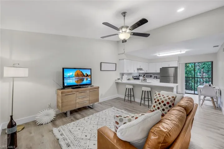 Living area with baseboards, light wood-style flooring, ceiling fan, and recessed lighting