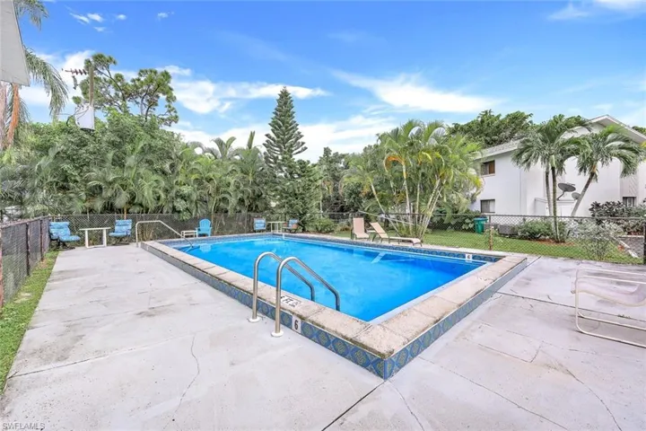 Community pool with fence and a patio