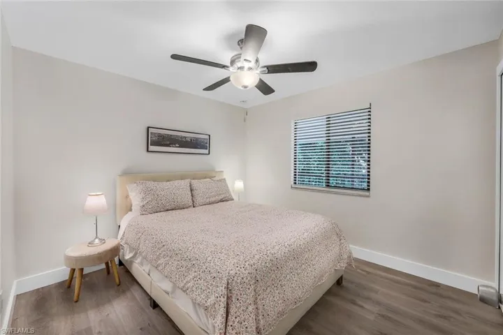 Bedroom featuring baseboards, wood finished floors, and ceiling fan