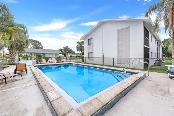 Community pool with fence and a patio area