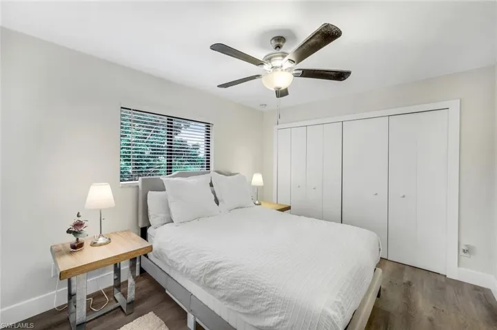 Bedroom featuring wood finished floors, baseboards, a closet, and ceiling fan