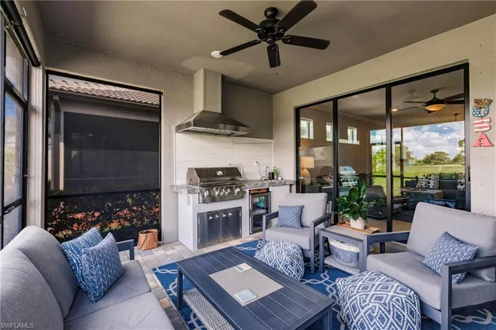 Extended lanai with outdoor kitchen, privacy shades and a ceiling fan
