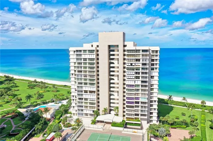 View of property with a water view and a beach view
