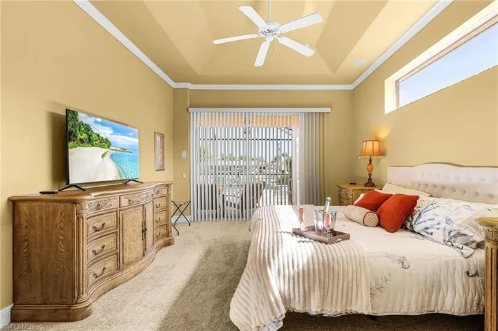 Primary Bedroom with King size bed, flatscreen tv and slider to the pool area