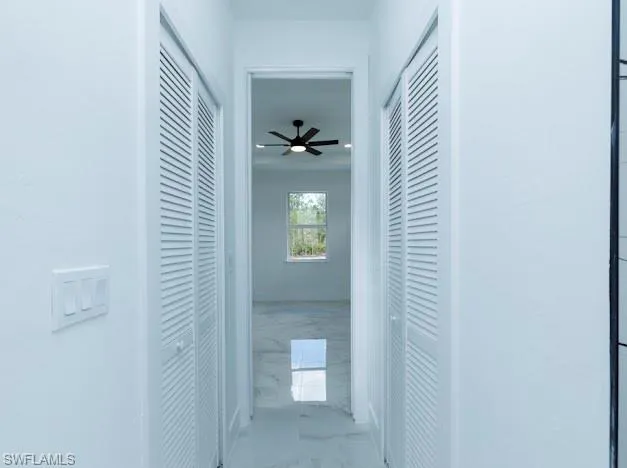 Corridor featuring marble tiled floors