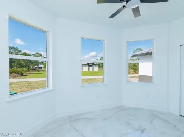 Empty room with marble finish floors and ceiling fan