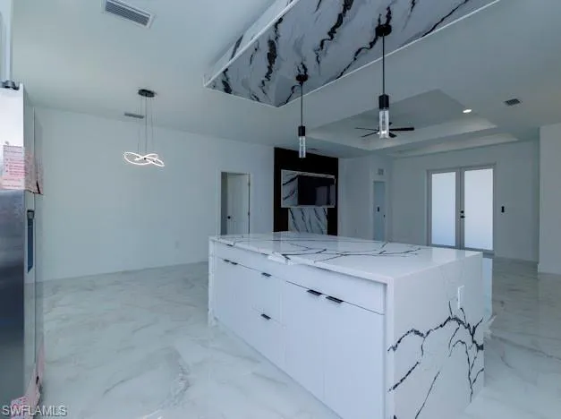 Kitchen with modern cabinets, open floor plan, a spacious island, and white cabinetry