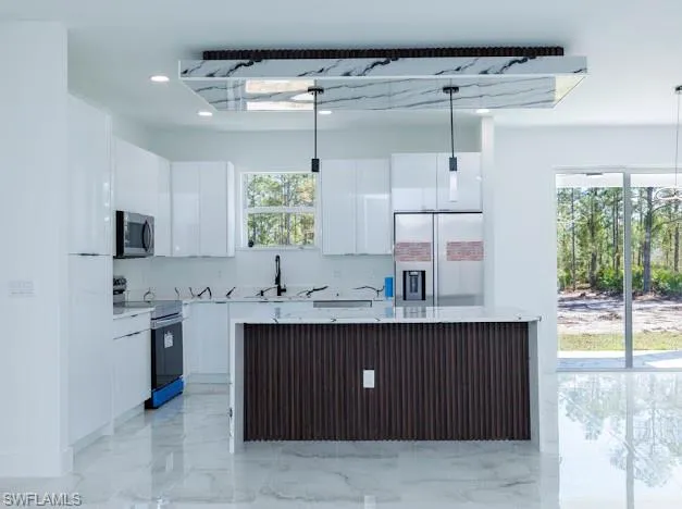 Kitchen featuring stainless steel appliances, white cabinets, plenty of natural light, and recessed lighting