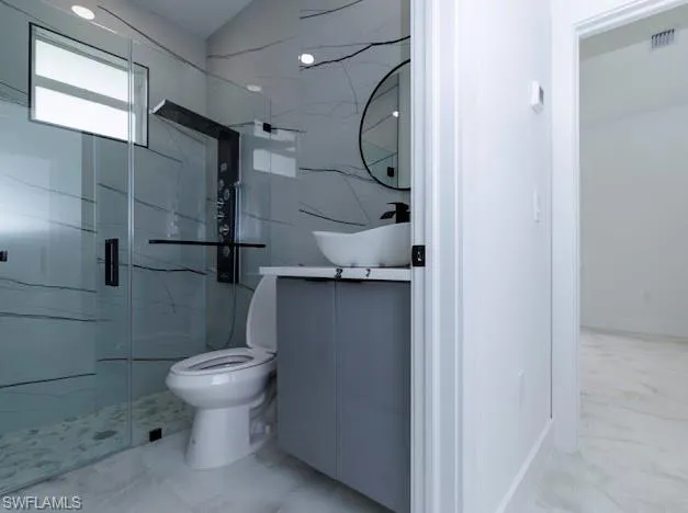 Full bath featuring marble finish flooring, vanity, and a marble finish shower