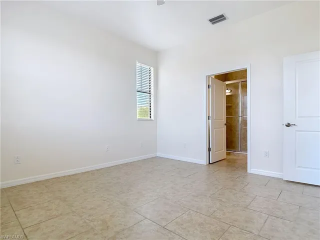 Unfurnished room with baseboards and visible vents