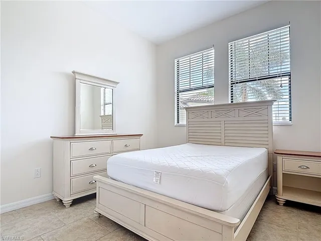 Bedroom featuring baseboards and light tile patterned flooring