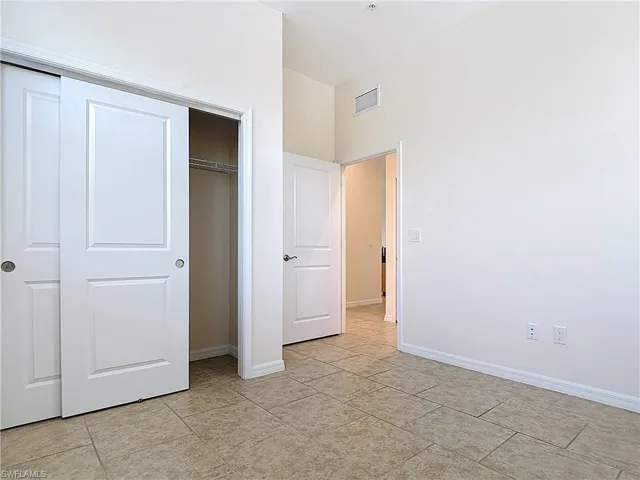 Unfurnished bedroom featuring a closet, visible vents, and baseboards