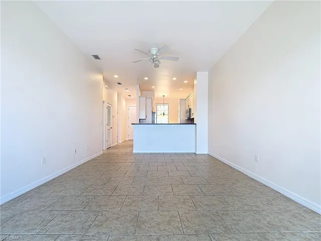 Unfurnished living room with recessed lighting, visible vents, baseboards, and ceiling fan