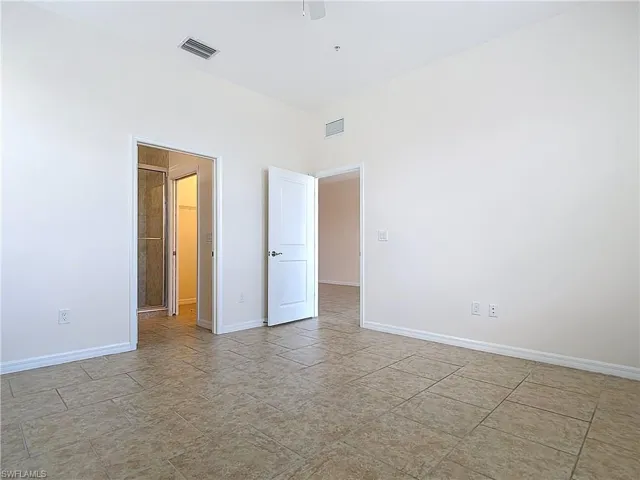 Empty room featuring ceiling fan, baseboards, and visible vents