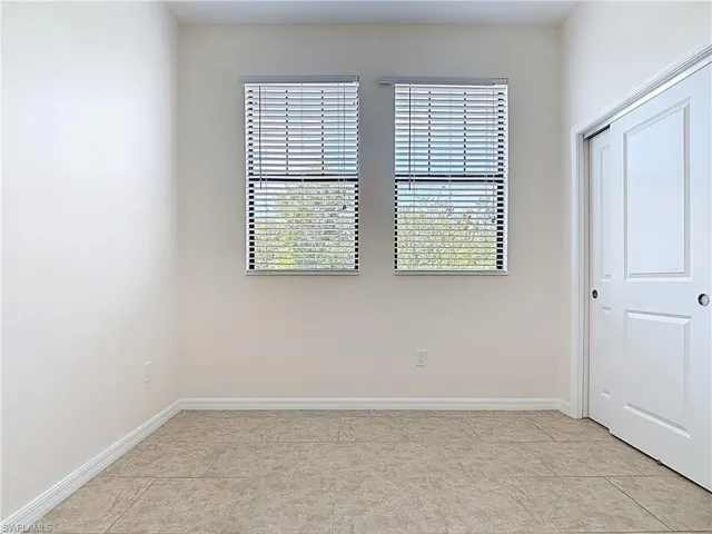 Unfurnished bedroom with baseboards and light tile patterned floors
