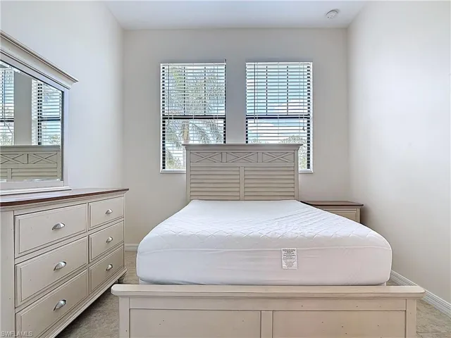 Bedroom featuring baseboards and light colored carpet