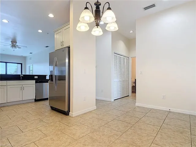 Kitchen featuring baseboards, visible vents, recessed lighting, ceiling fan with notable chandelier, and appliances with stainless steel finishes