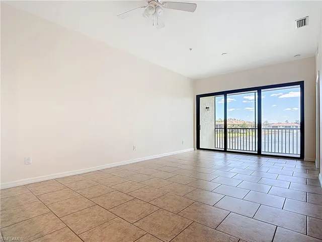 Spare room with ceiling fan, baseboards, light tile patterned flooring, and visible vents