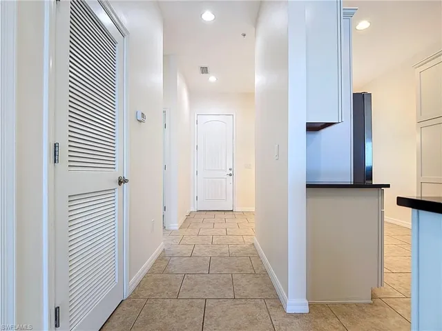 Hall with baseboards, recessed lighting, and light tile patterned flooring