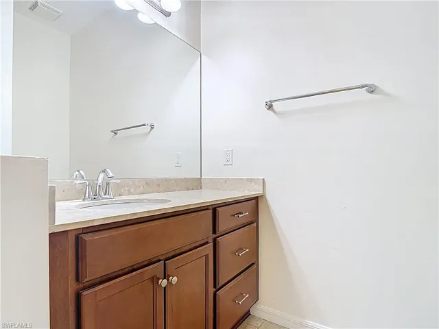 Bathroom featuring tile patterned floors, visible vents, and vanity