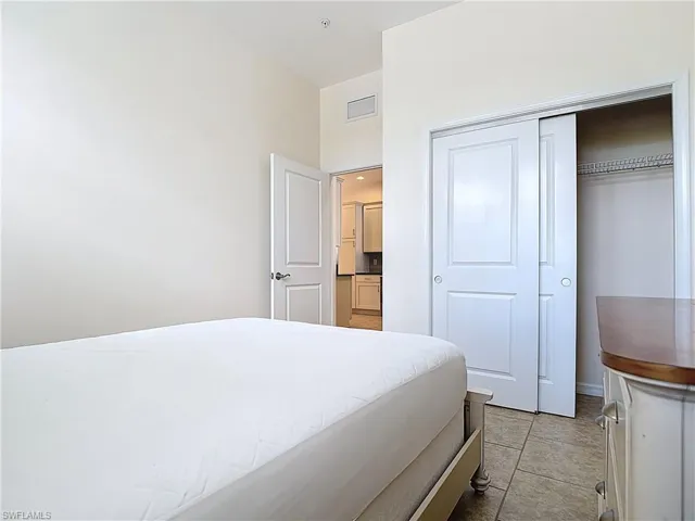 Bedroom with a closet, visible vents, and baseboards