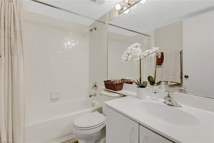 Full bathroom with vanity, shower / bath combo, and toilet