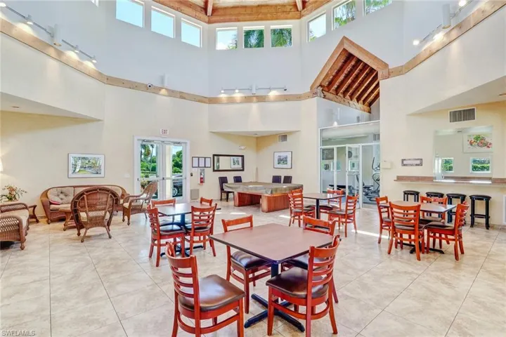 Tiled dining room with french doors and a towering ceiling