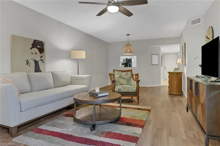 Living room with light wood-type flooring and ceiling fan
