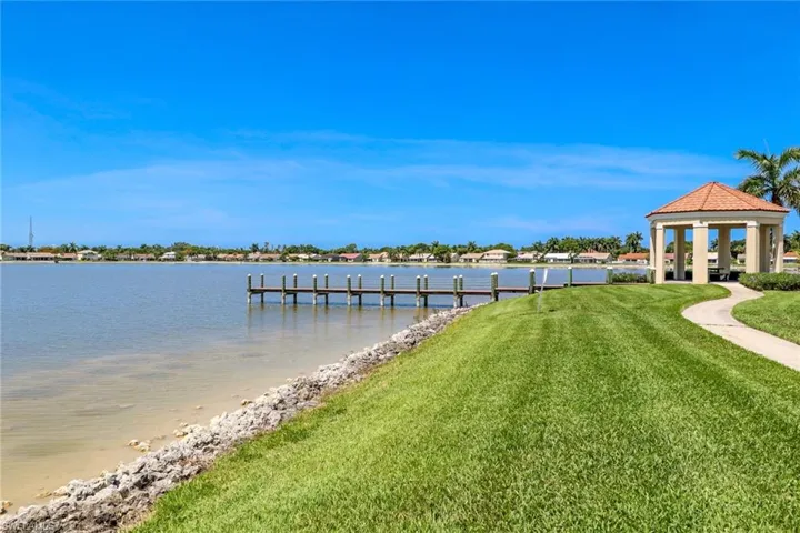View of dock with a gazebo, a yard, and a water view