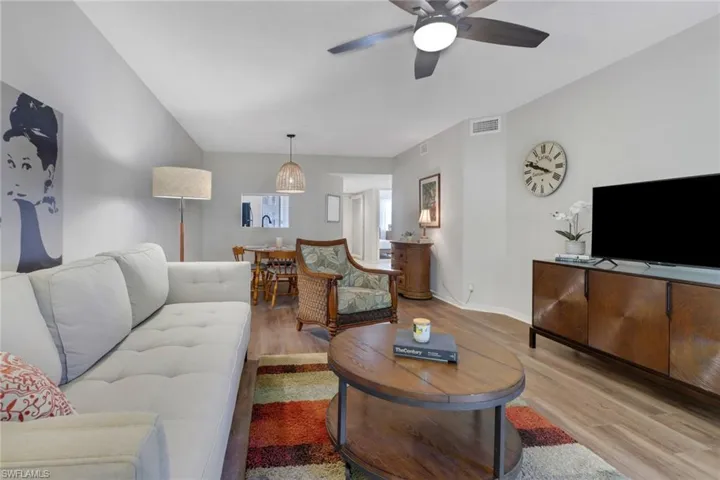 Living room with light hardwood / wood-style floors and ceiling fan